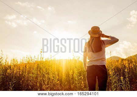 portrait of happy beautiful happy youngwoman relaxing in park. Joyful female model breathing fresh air outdoors and enjoying smell in a flower spring or summer garden vintage tone.