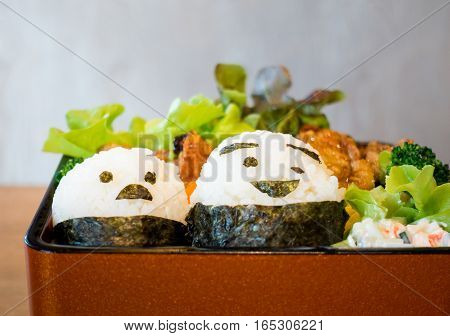 Japanese Bento with Smiley face on rice rolls.