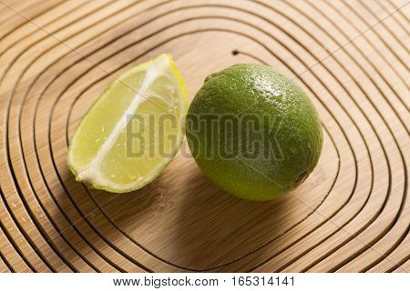 fresh green lemon on wooden background, closeup