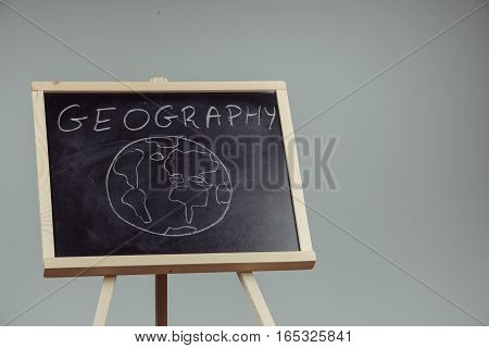 Geography Lesson On Blackboard Or Chalkboard. Written In White Chalk