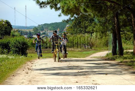 Vietnamese Children Ride Bicycle On Country Road
