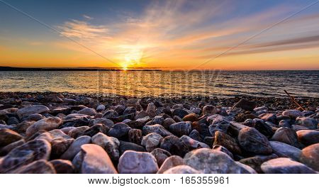 Stones On A Beach With Sunset On The Ocean Sea.