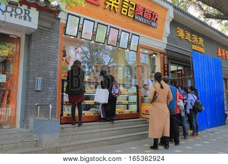 BEIJING CHINA - OCTOBER 29, 2016: Unidentified people queue to buy cakes in old futon street.