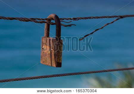 Closed padlock on cut iron rope represents insecurity