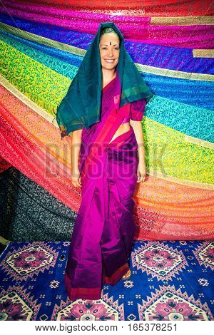Western woman with Indian clothes. Sari. A beautiful Caucasian smiling woman dressing typical Indian clothing. Dress symbol of India: Sari. Many bright colors.