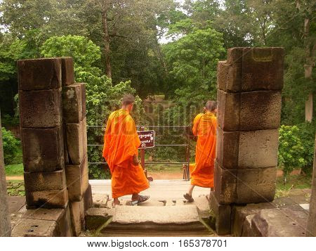 SIEM REAP, CAMBODIA - AUGUST 06, 2014 - Unidentified young buddhist monks inside the ruins of Baphuon temple