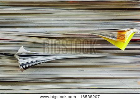 Closeup background of a pile of old magazines with bending pages