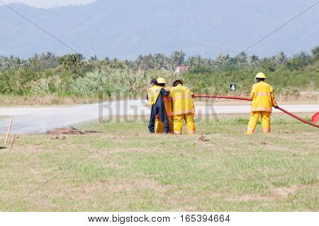 Firefighter in action spraying fire with fire hose