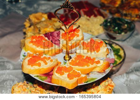 Bread butter red caviar on a beautiful tray festive table