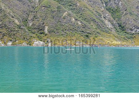 Minimal style photo with people at small boat sailing an inmense lake at Quilotoa crater Latacunga Ecuador