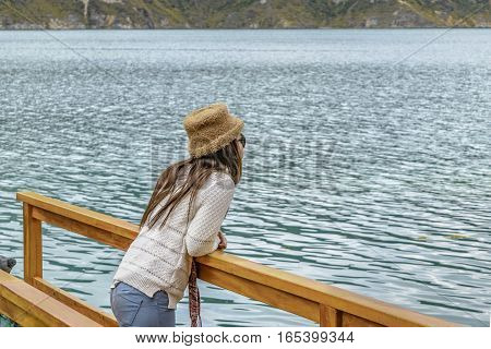 QUILOTOA, ECUADOR, FEBRAURY - 2016 - Young woman contemplating the view at Quilotoa lake Latacunga Ecuador
