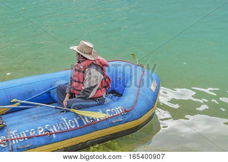 QUILOTOA, ECUADOR, FEBRAURY - 2016 - Adult worker man sitting at raft boat at Quilotoa lake Latacunga Ecuador