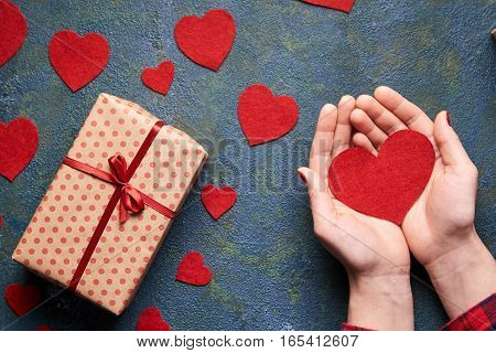 Heart in the hands of a lover. The concept of a romantic Valentine's Day. Gifts for lovers on Valentine. Symbol of love. Heart concrete background. Flat lay. Top view table.