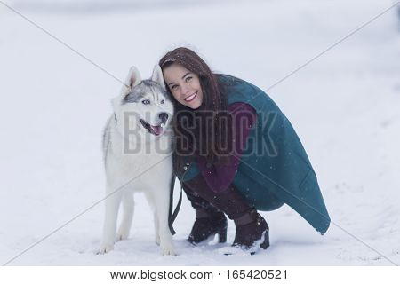Portrait of Pretty Smiling Woman Hugging Her Husky Dog Outside. Horizontal Image Composition