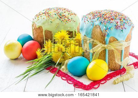 Traditional Easter treats: Easter cakes and colorful easter eggs on a white table