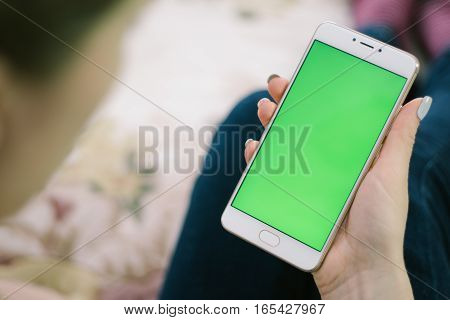 Beautiful girl holding a smartphone in the hands of a green screen green screen, hand of man holding mobile smart phone with chroma key green screen on white background, new technology concept