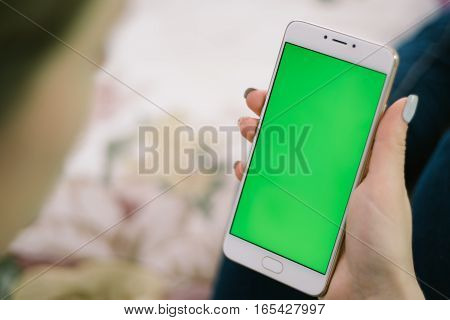 Beautiful girl holding a smartphone in the hands of a green screen green screen, hand of man holding mobile smart phone with chroma key green screen on white background, new technology concept