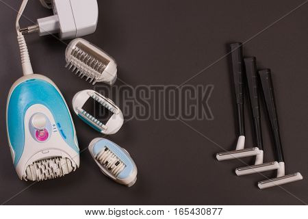 electric epilator with a razor on a dark background.