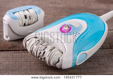 electric epilator on an old wooden background. Hair removal device