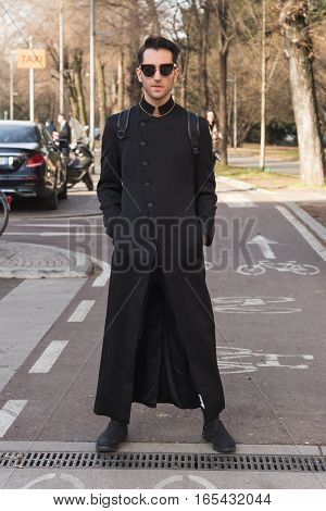 MILAN ITALY - JANUARY 14: Fashionable man poses outside Antonio Marras fashion show building during Milan Men's Fashion Week on JANUARY 14 2017 in Milan.