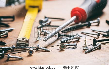 Screwdriver And Nails On Wooden Background
