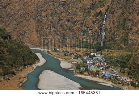 Colorful village Tal Annapurna Conservation Area Nepal. Turquoise Marsyangdi river. Waterfall.