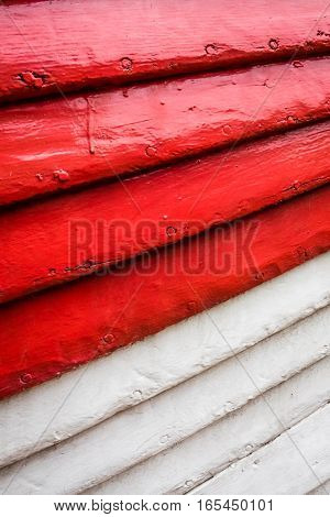 Red and white rows of painted wooden side of a fishermen boat