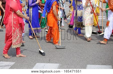Barefoot Women Of Sikh Religion Sweep The Road During The Celebr