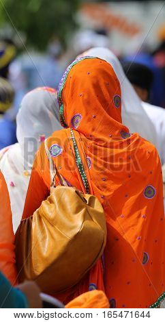 Woman With Orange Veil Headdress During A Gathering Of People
