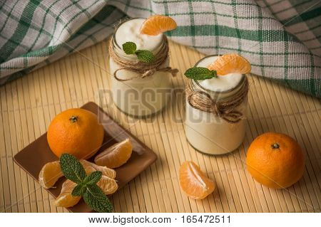 Fresh Organig Natural White Yogurt In Glass Jars With Tangerine And Mint