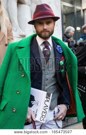 MILAN ITALY - JANUARY 15: Fashionable man poses outside Ferragamo fashion show building during Milan Men's Fashion Week on JANUARY 15 2017 in Milan.