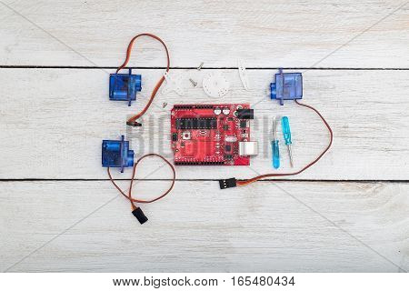 the robot assembly elements. servo servo motors printed circuit board a screwdriver