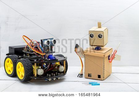 two robots are on the table the robot is repairing another robot