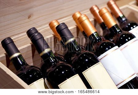 Wine shop. Closeup shot of wineshelf. Bottles lay over straw.