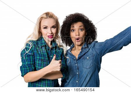 Two beautiful girls making selfie. Isolated on white background. young woman looking into the camera
