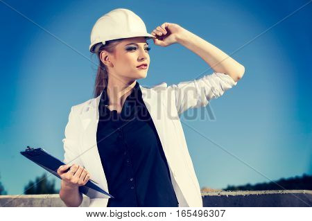 Female Engineer In Helmet In Front Of Construction Site