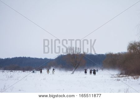 Pietrosani Romania - January 6 2017: People race their horses on a snowy field during a traditional Epiphany horse race in Pietrosani Romania.