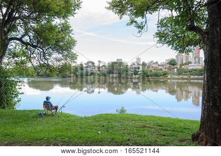 Londrina, Pr, Brazil - December 24, 2016: Man Fishing On The Shore Of Lake Igapo In Londrina. Man Si