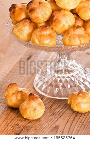 Group of sweet cream puffs on glass tray.