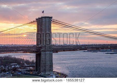 New York City colorful sunset landscape scene with the Brooklyn Bridge across the East River towards Manhattan