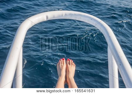 vacation holiday wooman feet on white yacht bow above sea