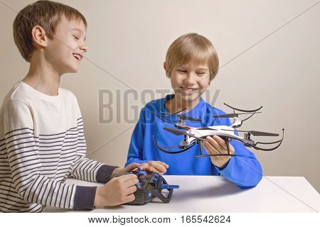 Little happy kids playing with the quadcopter drone at home. Technology, education, leisure, toys concept