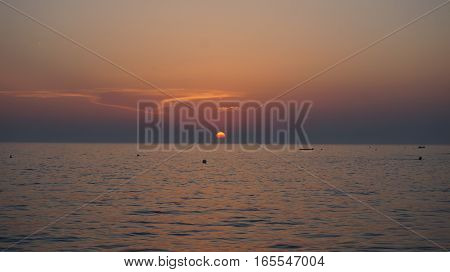 the sun sets over the calm sea adriatic