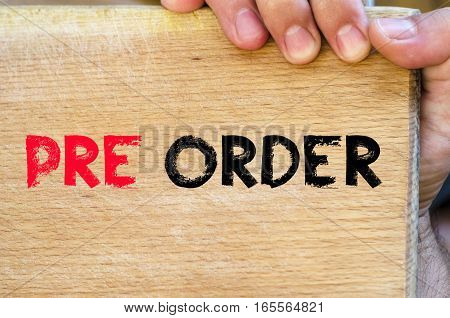 Human hand over wooden background and pre order text concept