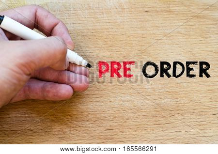 Human hand over wooden background and pre order text concept