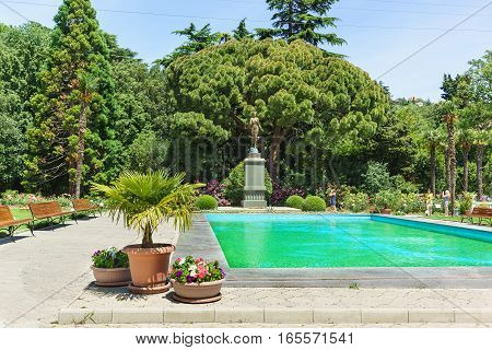 Russia, Crimea, Yalta, Nikita Botanical garden June 09.2016: Pool and a sculpture of Flora