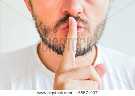 Bearded man making silence gesture, pst, shh, face detail