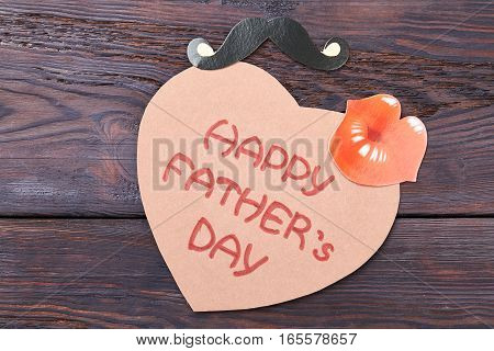 Father's Day card and props. Heart-shaped card on wood. Cute greeting for dad.