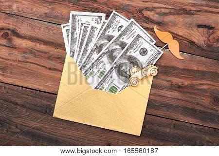 Money in envelope and mustache. Pyrography car and dollars. Invest in art.