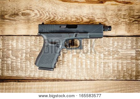 top view of a black pistol on a wooden table